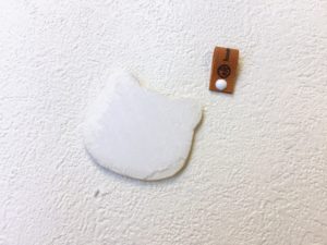 猫型パーツに革タグを取り付ける工程